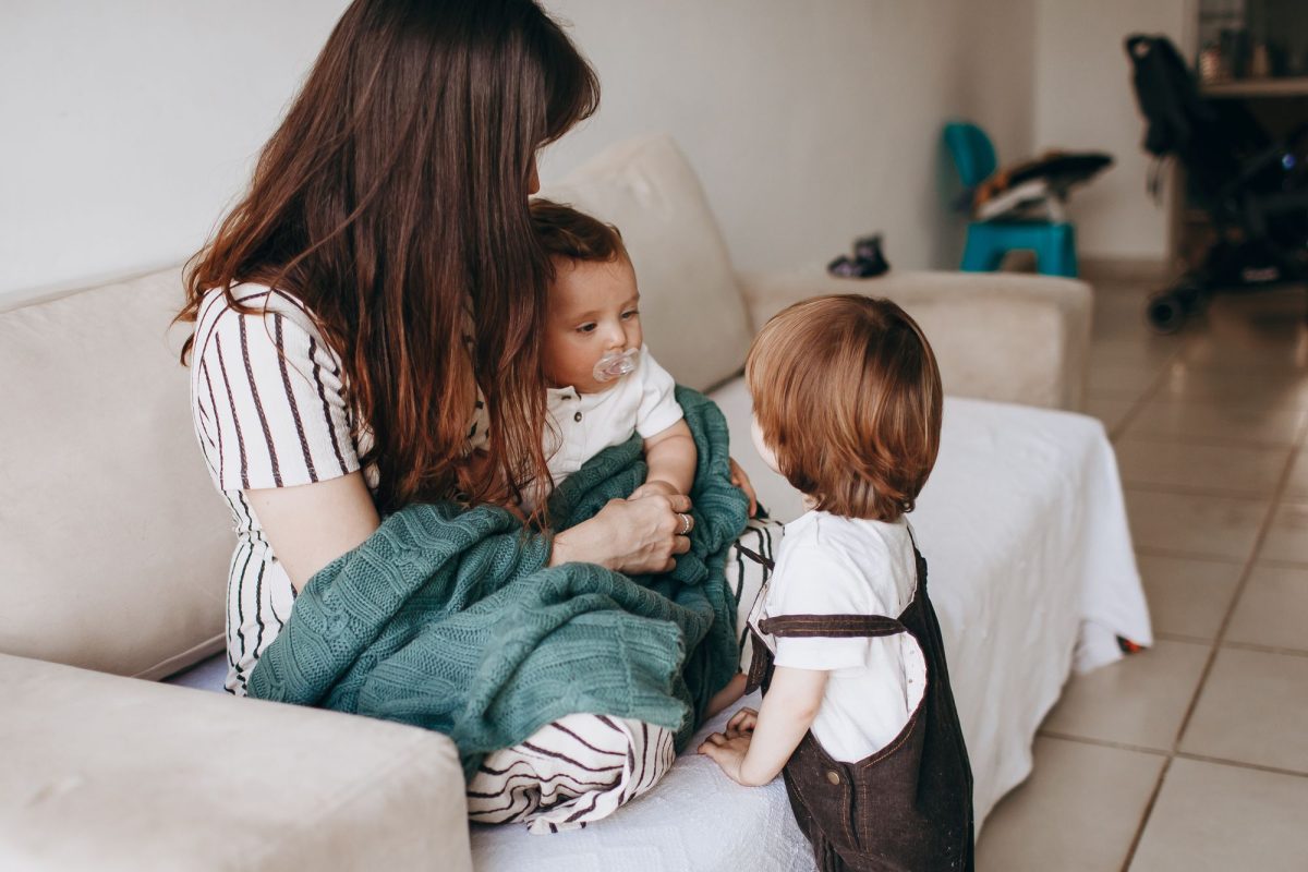 Parents avec leurs jeunes enfants sur un canapé à la maison