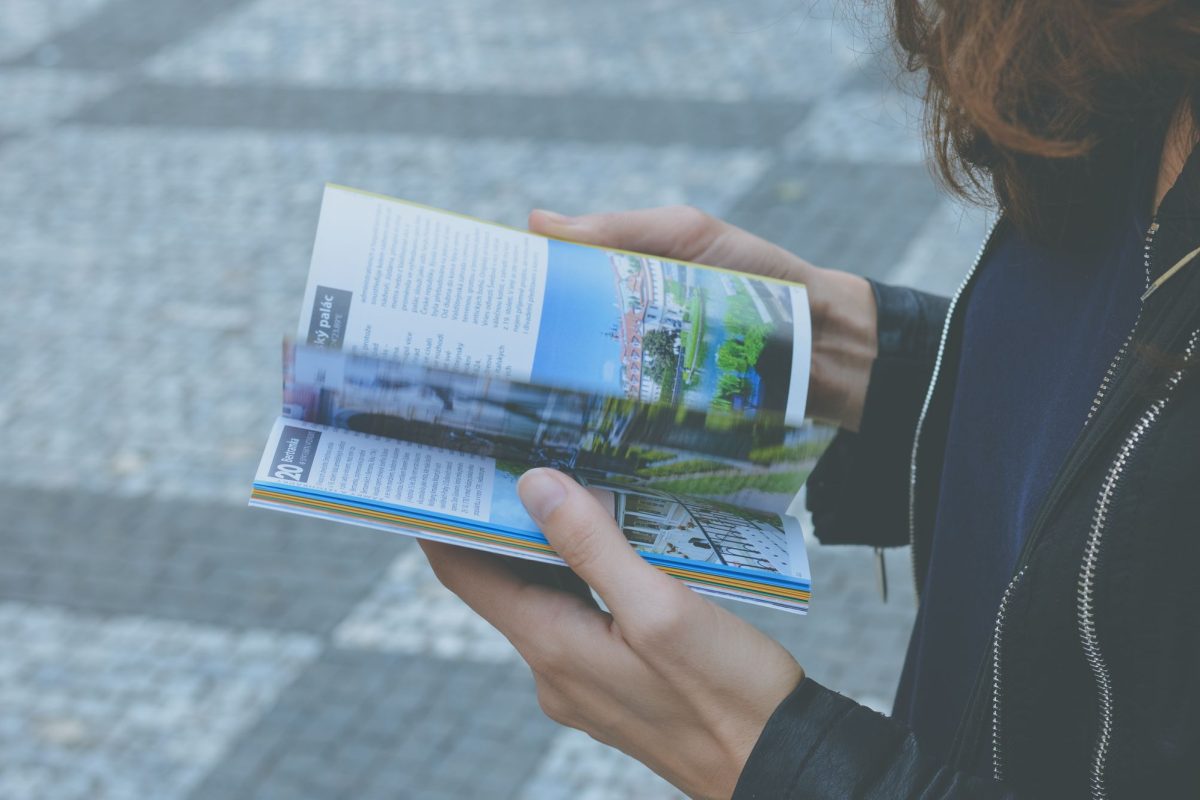 Main tenant un guide de voyage ouvert dans la rue