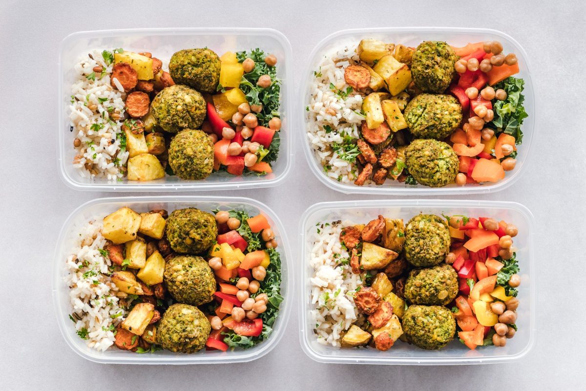 Quatre boîtes repas préparées pour la semaine avec riz, boulettes de pois chiches et légumes