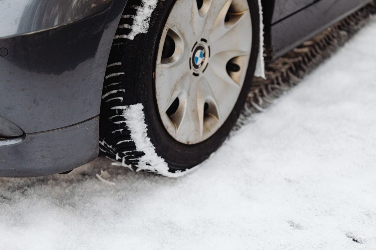 Roue de voiture avec pneu hiver sur la neige