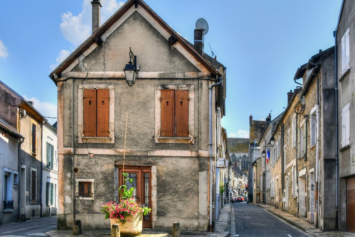 Rue étroite d'un village français aux maisons de pierre et aux volets de bois