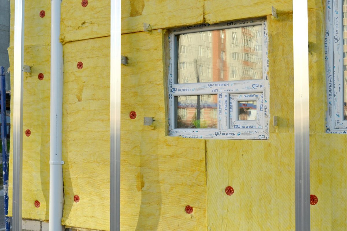 Façade d'un bâtiment isolée par des panneaux de laine minérale jaune